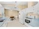 Bright kitchen features white appliances and a built-in breakfast table at 2411 Greenlaw Ct, Leesburg, FL 34788