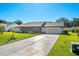 Ranch-style home with a screened porch, mature landscaping, and a two-car garage at 2411 Greenlaw Ct, Leesburg, FL 34788
