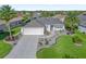 Single-story home with a paved driveway, landscaped yard and two-car garage at 3358 Quail Hollow Ct, The Villages, FL 32163