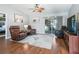 Relaxing living room featuring hardwood floors, two leather recliners, and sliding glass doors at 3358 Quail Hollow Ct, The Villages, FL 32163