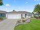 Single-story home with a white exterior, landscaped yard, and a two-car garage at 3358 Quail Hollow Ct, The Villages, FL 32163