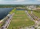 Aerial view of a community with several soccer fields, parking lots, and a lake at 10156 Ballast Dr, Orlando, FL 32827