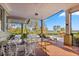 Covered patio with lake view, seating, and dining area at 17601 Sawgrass Run, Tavares, FL 32778