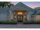 Elegant home entrance with grand double doors at dusk at 17601 Sawgrass Run, Tavares, FL 32778