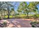 Brick patio with lush landscaping and water view at 17601 Sawgrass Run, Tavares, FL 32778
