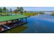 Private covered dock with a boat lift on a calm lake at 17601 Sawgrass Run, Tavares, FL 32778