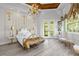 Luxurious bedroom with a gold and white bed frame and hardwood floors at 17601 Sawgrass Run, Tavares, FL 32778