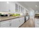 Long kitchen with granite countertops and glass-front cabinets at 17601 Sawgrass Run, Tavares, FL 32778