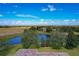Stunning aerial view showcasing home, pond, and landscape at 25611 Maurepas Ln, Leesburg, FL 34748