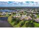 Aerial view of houses near a lake in a residential area at 25611 Maurepas Ln, Leesburg, FL 34748