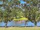 Peaceful backyard with a bench nestled between trees near a pond at 25611 Maurepas Ln, Leesburg, FL 34748