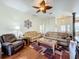 Comfortable living room with a large sectional sofa and hardwood floors at 25611 Maurepas Ln, Leesburg, FL 34748