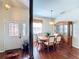Formal dining room adjacent to the entryway, featuring hardwood floors and a china cabinet at 25611 Maurepas Ln, Leesburg, FL 34748