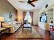Comfortable living room showcasing hardwood floors and a ceiling fan at 25611 Maurepas Ln, Leesburg, FL 34748