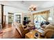 Spacious living room with hardwood floors, a ceiling fan, and access to the patio at 25611 Maurepas Ln, Leesburg, FL 34748
