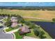 Aerial view of a house and neighborhood with a lake nearby at 25611 Maurepas Ln, Leesburg, FL 34748