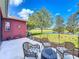 Patio with wicker furniture and view of pond and trees at 25611 Maurepas Ln, Leesburg, FL 34748