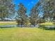 Scenic backyard featuring a tranquil pond and a relaxing bench at 25611 Maurepas Ln, Leesburg, FL 34748