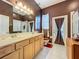 Bathroom with double vanity, toilet, and shower at 25611 Maurepas Ln, Leesburg, FL 34748