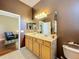 Double vanity bathroom with light wood cabinets and a view of a sitting area at 25611 Maurepas Ln, Leesburg, FL 34748