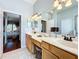 Bright bathroom with double vanity and a view into bedroom at 25611 Maurepas Ln, Leesburg, FL 34748
