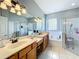 Bathroom with double vanity, soaking tub, and walk-in shower at 25611 Maurepas Ln, Leesburg, FL 34748