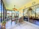 Bright screened porch with seating area and view of backyard at 25611 Maurepas Ln, Leesburg, FL 34748