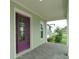 Covered front porch with purple door and view of the neighborhood at 9934 Fiddley Aly, Orlando, FL 32827