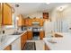 Functional kitchen with wood cabinets, stainless steel appliances, and a breakfast bar at 1312 Landeros Ln, The Villages, FL 32159