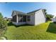 Backyard view of home with screened porch and lush lawn at 1312 Landeros Ln, The Villages, FL 32159