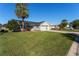 House exterior with a two-car garage and a palm tree at 1312 Landeros Ln, The Villages, FL 32159