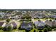 Aerial view of houses with green lawns and a golf course in the distance at 1312 Landeros Ln, The Villages, FL 32159