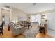 Cozy living room featuring a leather couch, hardwood floors, and tasteful artwork at 1312 Landeros Ln, The Villages, FL 32159