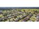 Aerial view showcasing a neighborhood's houses, green spaces, and golf course at 1312 Landeros Ln, The Villages, FL 32159