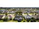 Aerial view showing houses, landscaping, and a golf course in the background at 1312 Landeros Ln, The Villages, FL 32159
