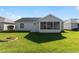 Home's exterior boasts a screened porch and grassy yard at 1312 Landeros Ln, The Villages, FL 32159
