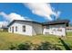 White house with black trim, a grassy lawn, and a fire pit at 2030 Leisure Dr, Winter Haven, FL 33881