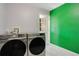 Laundry room with Samsung washer and dryer and green accent wall at 2030 Leisure Dr, Winter Haven, FL 33881