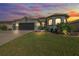 Attractive home with a two-car garage, illuminated at dusk at 17257 Se 113Th Ave, Summerfield, FL 34491