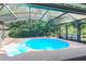 Circular pool with spa, screened enclosure, and lush landscaping at 1233 Overlook Rd, Eustis, FL 32726