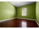 Bright bedroom with green walls, wood flooring, and a window with blinds at 9832 Florida Boys Ranch Rd, Clermont, FL 34711