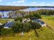 Aerial view of a lakefront property with two houses and a large yard at 9832 Florida Boys Ranch Rd, Clermont, FL 34711