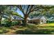Large backyard with mature trees and green lawn at 3064 Windham Dr, Eustis, FL 32726