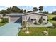 Mobile home with a single-car garage and landscaped yard at 25504 Belle Alliance, Leesburg, FL 34748