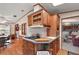 Kitchen island with cooktop, wood cabinets, and views into the dining area at 25504 Belle Alliance, Leesburg, FL 34748