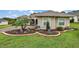 Landscaped yard with curved retaining wall and decorative plants at 5096 Greens Dr, Lady Lake, FL 32159