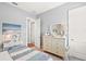 Light and airy bedroom with full bed, dresser, and adjacent bathroom access at 5096 Greens Dr, Lady Lake, FL 32159