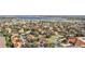 Wide aerial view of a community with numerous townhomes, a pool, and a lake at 5279 Bowline Ct, Oxford, FL 34484