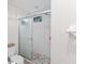 Shower with glass sliding doors and pebble tile floor at 5279 Bowline Ct, Oxford, FL 34484