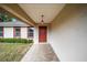 Covered porch with tile flooring and a red door at 2101 Sw 3Rd St, Ocala, FL 34471